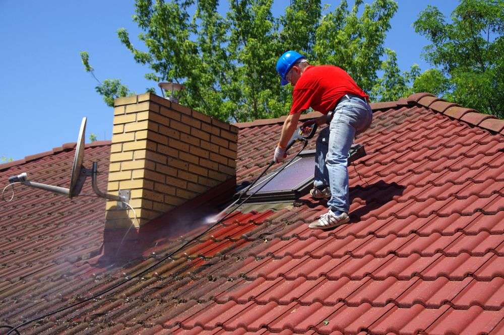 Schoonspuiten van de dakpannen in Almere